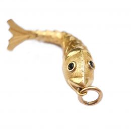 High carat gold articulated fish pendant, the eyes sapphire set
