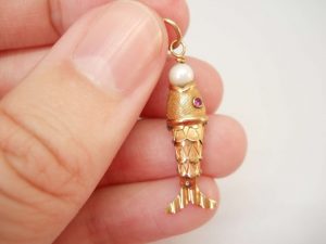 Articulated fish charm with a pearl set to mouth