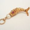 Articulated fish charm with a pearl set to mouth