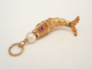 Articulated fish charm with a pearl set to mouth