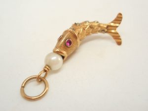 Articulated fish charm with a pearl set to mouth