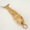 Fine vintage gold articulated fish pendant with pink gem set eyes