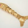 Fine vintage gold articulated fish pendant with pink gem set eyes