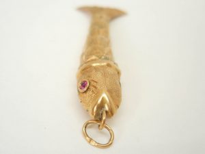 Fine vintage gold articulated fish pendant with pink gem set eyes