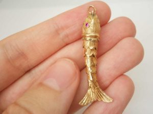 Fine vintage gold articulated fish pendant with pink gem set eyes