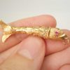 Fine vintage gold articulated fish pendant with pink gem set eyes