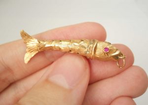 Fine vintage gold articulated fish pendant with pink gem set eyes