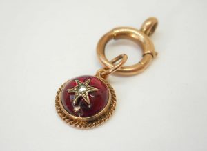 Victorian star set garnet 9ct gold charm on a 9ct gold bolt ring, both circa 1900