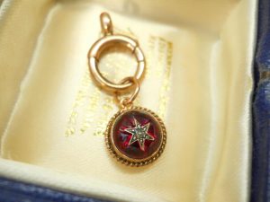 Victorian star set garnet 9ct gold charm on a 9ct gold bolt ring, both circa 1900